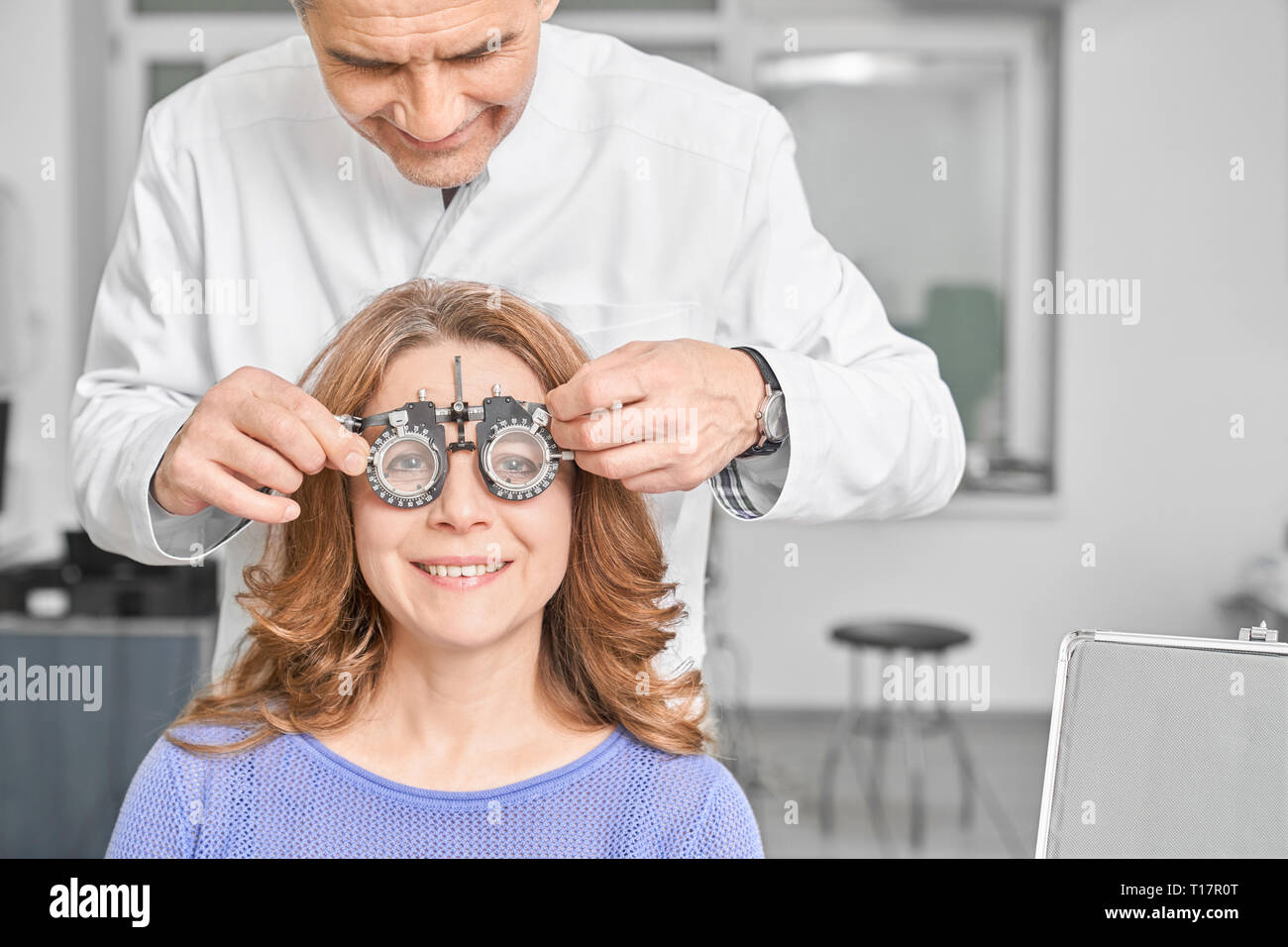 Arzt, Augenarzt Untersuchung Sehvermögen des Patienten in der Klinik. Professionelle Augenarzt spezielle Ausrüstung, Frau Test tragen eine Brille. Konzept der Sehkraft Korrektur. Stockfoto