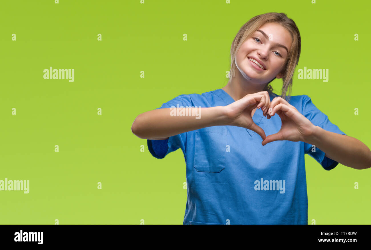 Junge kaukasier Krankenschwester Frau tragen Chirurgen gleichmäßig über isolierte Hintergrund lächelnd in Liebe mit Herz und Formen mit den Händen. Romantische conce Stockfoto