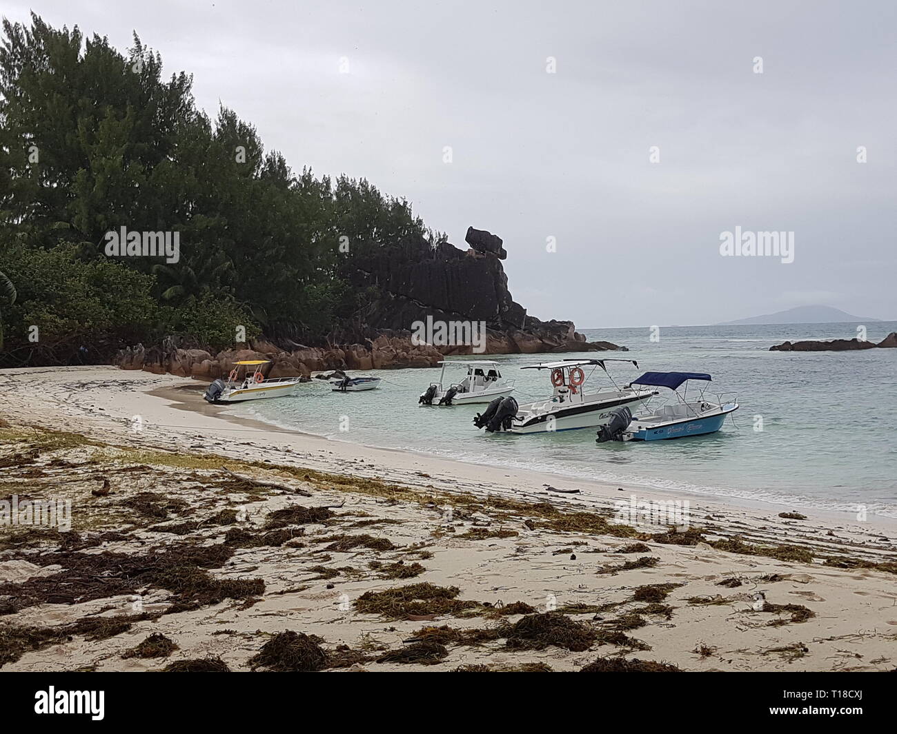 Boote an der Küste der tropischen Insel Curieuse auf den Seychellen Stockfoto