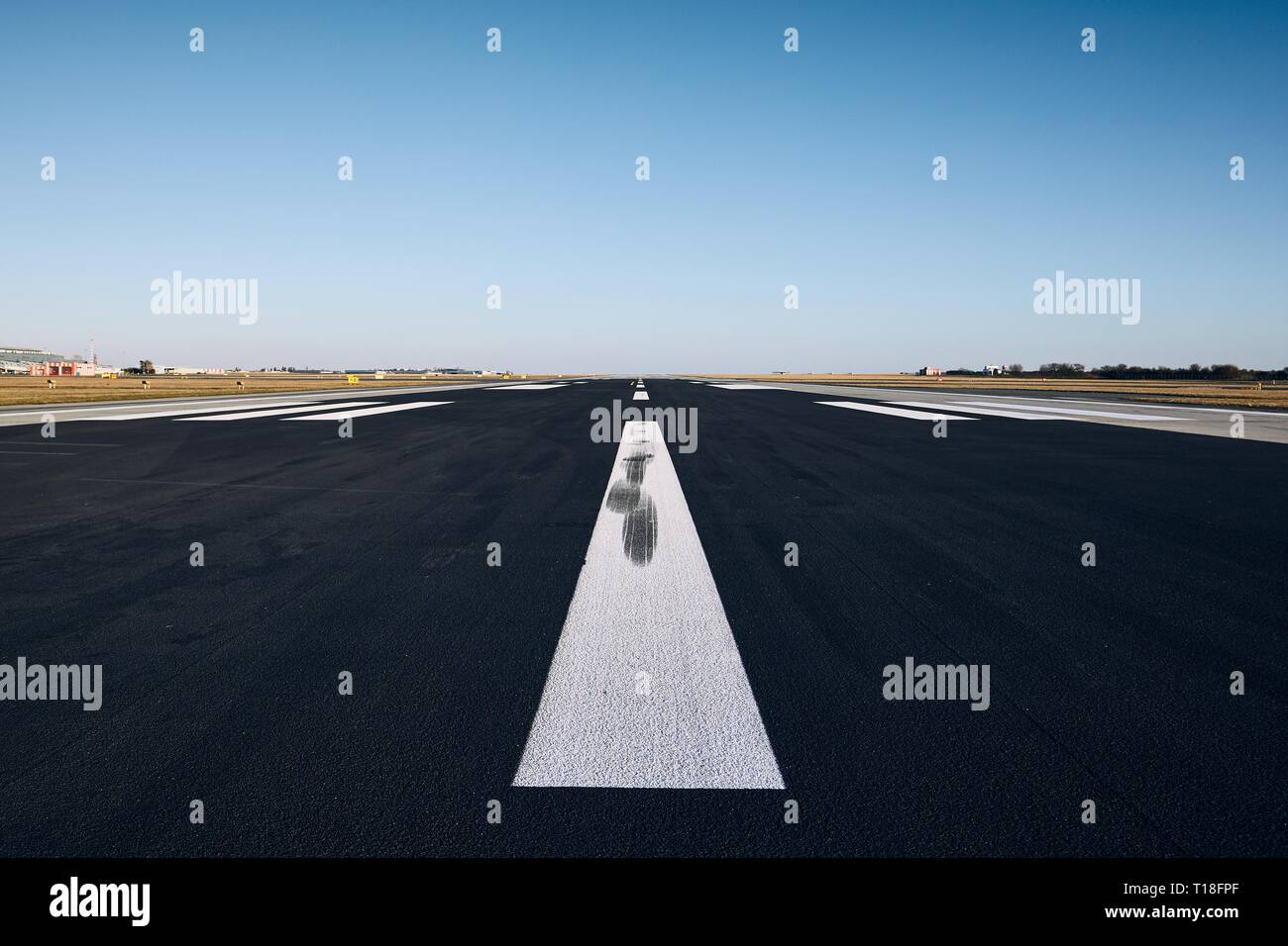Oberfläche der Landebahn mit straßenmarkierung gegen den klaren Himmel. Stockfoto