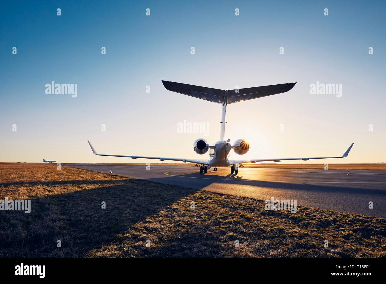 Flughafen bei Sonnenuntergang. Silhouette von privaten Strahl gegen die Start- und Landebahn. Stockfoto