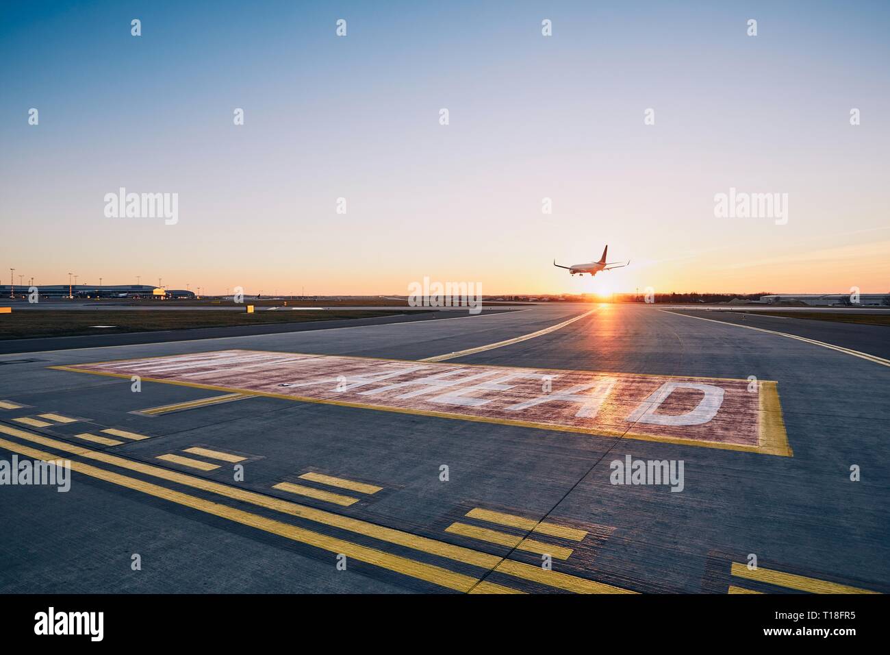 Start- und Landebahn vor. Flugzeug Landung am Flughafen während des Sonnenuntergangs. Stockfoto