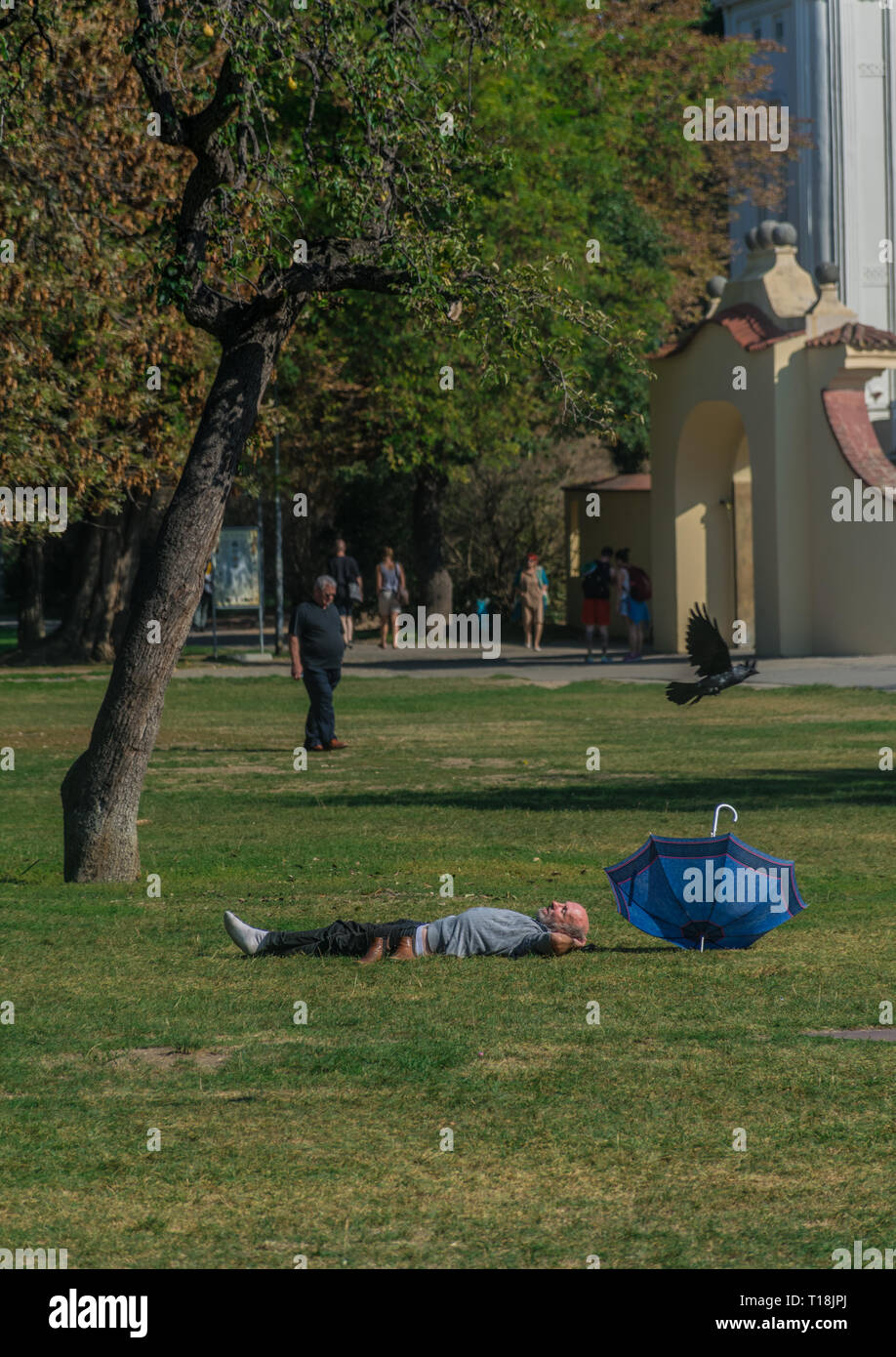 Prag, Tschechische Republik - 10 September, 2019: fett Mann schläft auf dem Gras an einem sonnigen Tag an Kampa Park Stockfoto