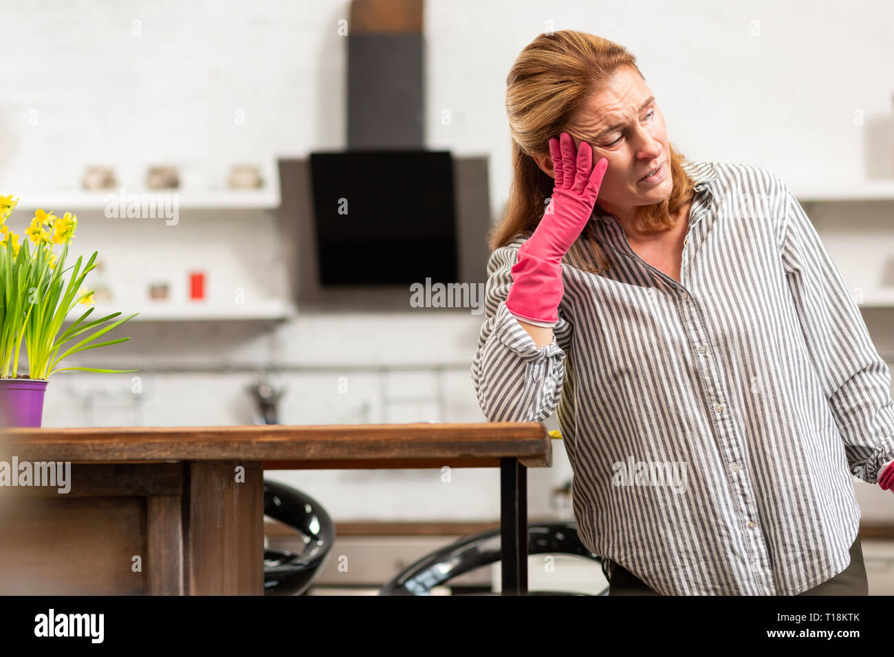 Reife Hausfrau Gefühl mit ihrem starken Allergie zu Blumen in Angst und Schrecken Stockfoto