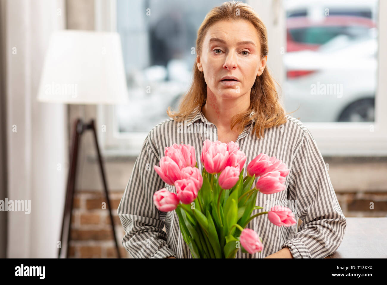 Frau mit rosa Blumen Gefühl empfindlich auf blühenden Stockfoto