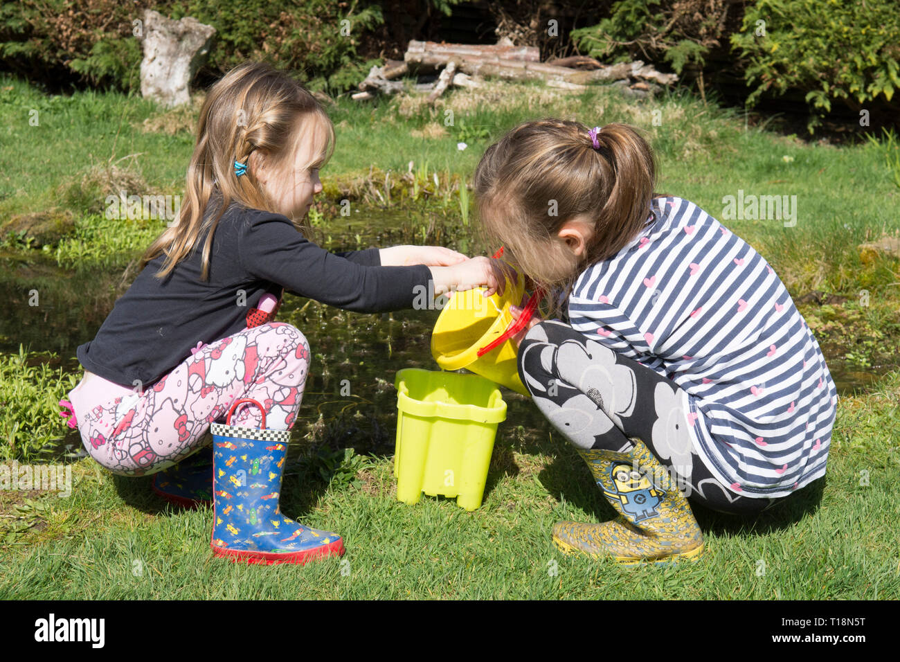 Zwei junge Mädchen Teich Eintauchen in Garten Tiere Teich Kaulquappen