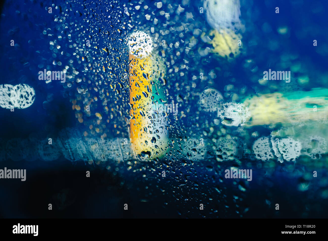 Nacht Lichter der Stadt durch die Windschutzscheibe abstrakt hintergrund Wasser Tropfen auf dem Glas Licht und Regen Stockfoto