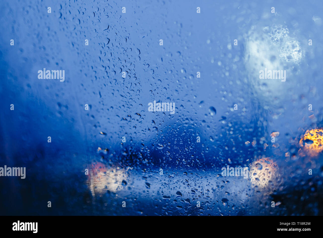 Nacht Lichter der Stadt durch die Windschutzscheibe abstrakt hintergrund Wasser Tropfen auf dem Glas Licht und Regen Stockfoto