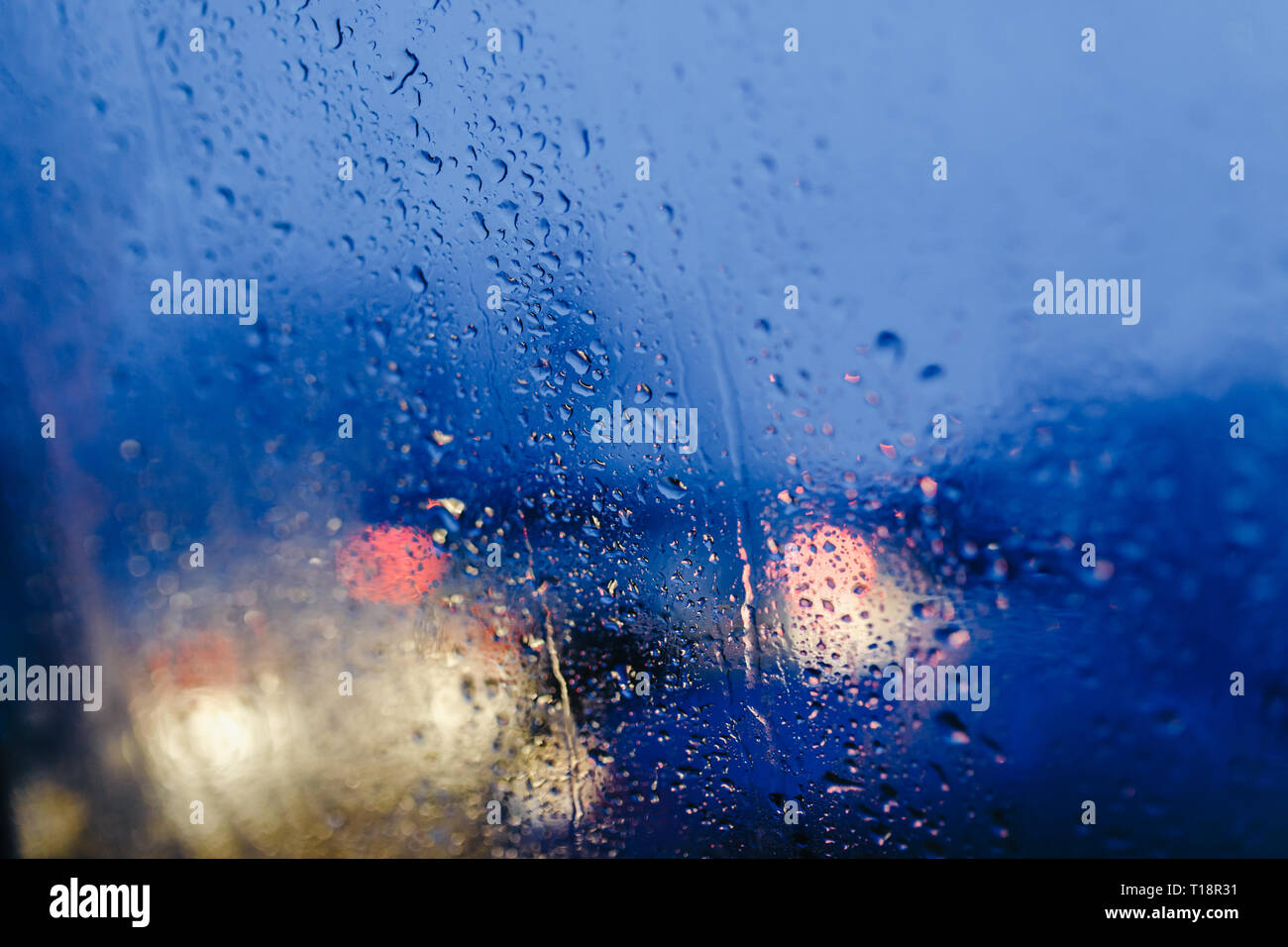 Nacht Lichter der Stadt durch die Windschutzscheibe abstrakt hintergrund Wasser Tropfen auf dem Glas Licht und Regen Stockfoto