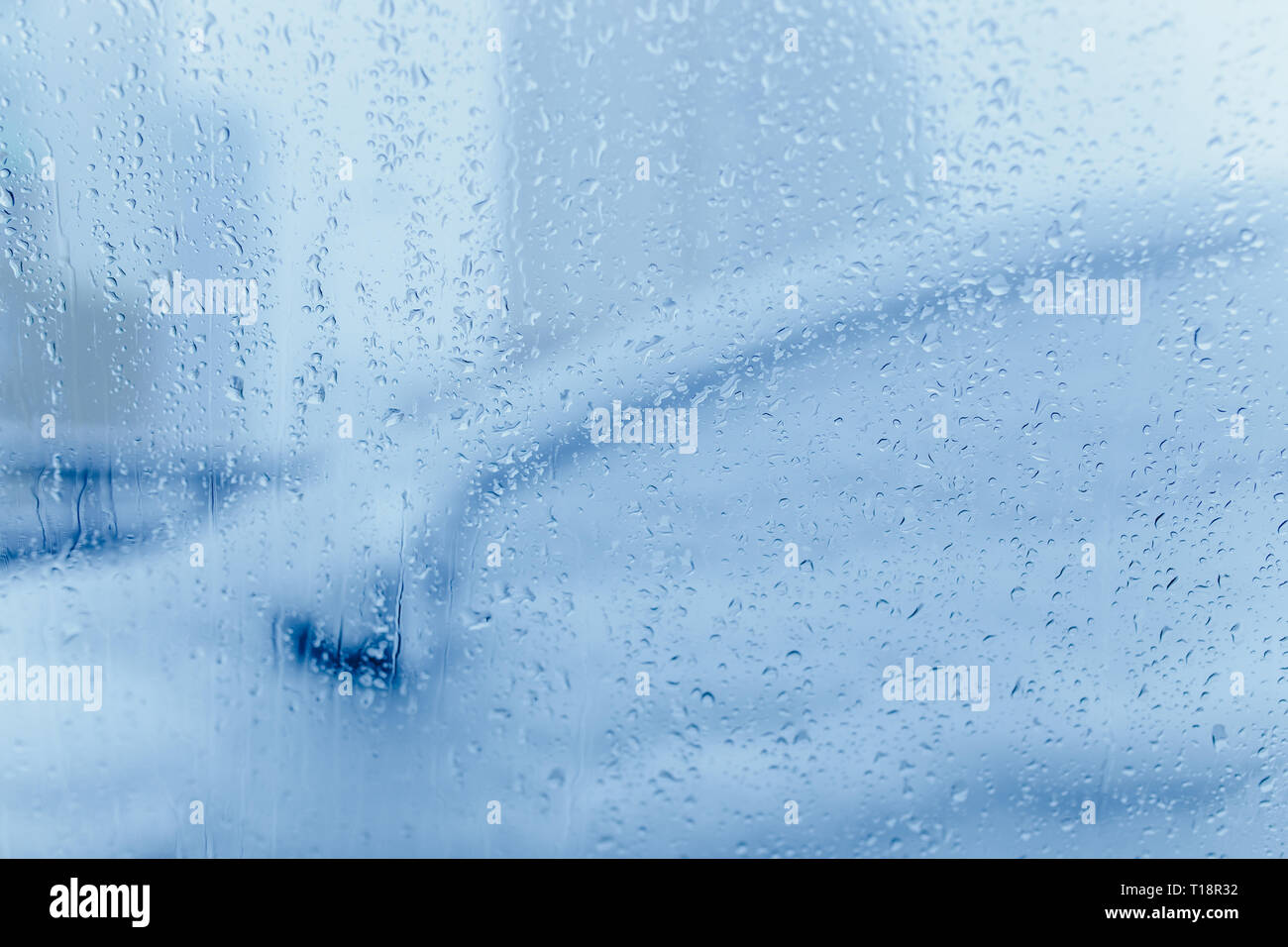 Verkehr Abstract im Winter. Verkehr von in einem Auto gesehen. Wassertropfen auf der Windschutzscheibe und Auto Rückleuchten im Bokeh Stockfoto