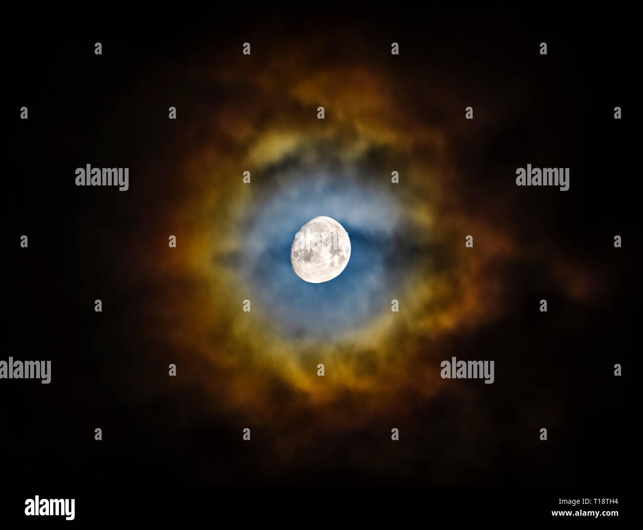 Waxing gibbous Mond durch die Wolken eine lebendige, farbenfrohe und Halo glänzen. Natürliches Phänomen, keine Composite. Schöne und malerische skyscape. Stockfoto