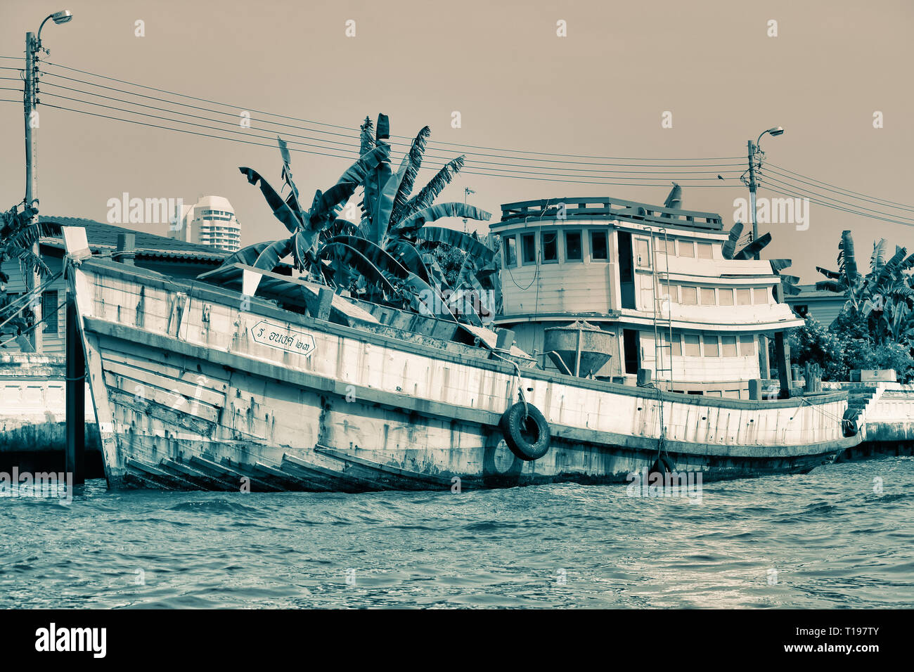Dieses einzigartige Bild zeigt einen alten verworfen Geisternetze Boot auf dem Mae Nam Chao Phraya Fluss in Bangkok. Stockfoto