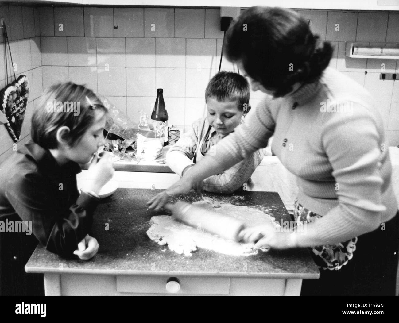 Haushalt, Kochen und Backen, zwei Kinder beobachten ihre Mutter die Einführung der Paste für Weihnachtsgebäck, 1970, Additional-Rights - Clearance-Info - Not-Available Stockfoto