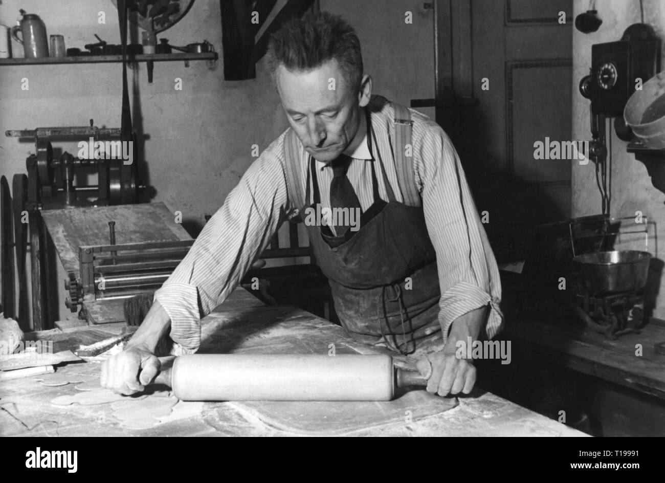 Menschen, Beruf, Bäcker/Konditor, ältere Baker heraus rollen einfügen, 1930er Jahre, arbeiten, arbeiten, arbeiten, arbeiten, arbeiten, Arbeit, Arbeitsmarkt, Handwerk, Handwerk, Handwerk, Handwerker, Handwerker, Handwerker, Handwerker, Handwerker, Händler, Handwerker, Ernährung, Diät, essen, Lebensmittel, halbe Länge, halbe Länge, stehend, Hemd, Hemden, Krawatte, Krawatte, Krawatte, Krawatten, Schürze, Schürzen, Tisch, Tische, Rollen, Rollen, Rollen, Beruf, Berufe, Konditor, Konditoren, Bäcker, Bäcker, Roll Out, Roll-out, rollt, ausgerollt, historische, h, Additional-Rights - Clearance-Info - Not-Available Stockfoto