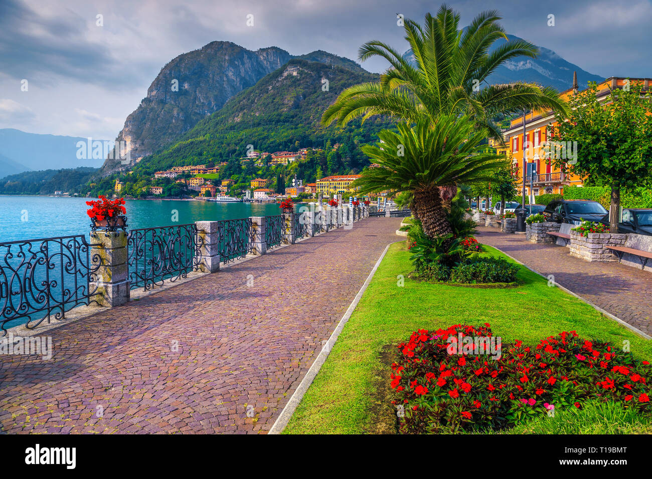 Sommerurlaub Lage, spektakuläre Promenade mit bunten Blumen im öffentlichen Park und Palmen am Ufer, Comer See, Menaggio, Region Lombardei, Stockfoto