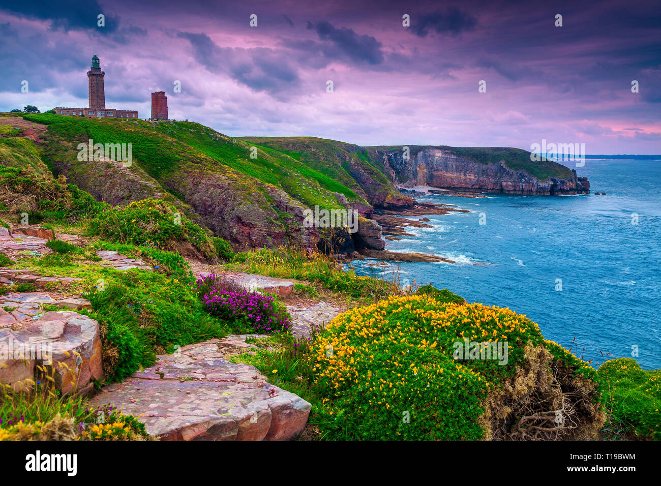 Spektakuläre Leuchtturm von Cap Frehel mit blumigen und felsigen Küste bei Sonnenaufgang. Fantastisches Reiseziel in der Bretagne, Frankreich, Europa Stockfoto