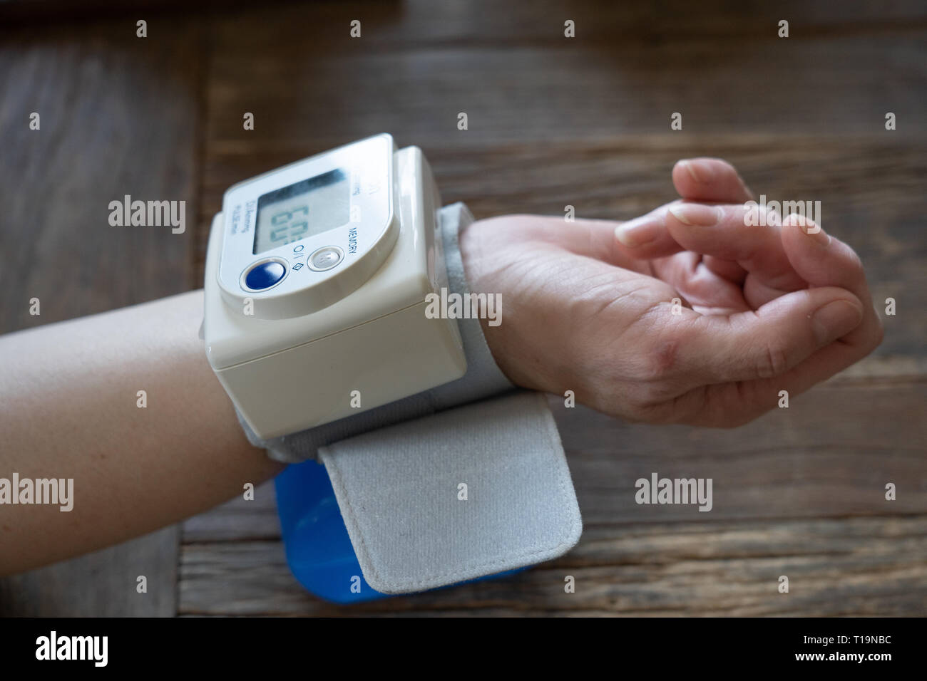 Frau mittleren Alters nimmt Ihren Blutdruck zu Hause Stockfoto