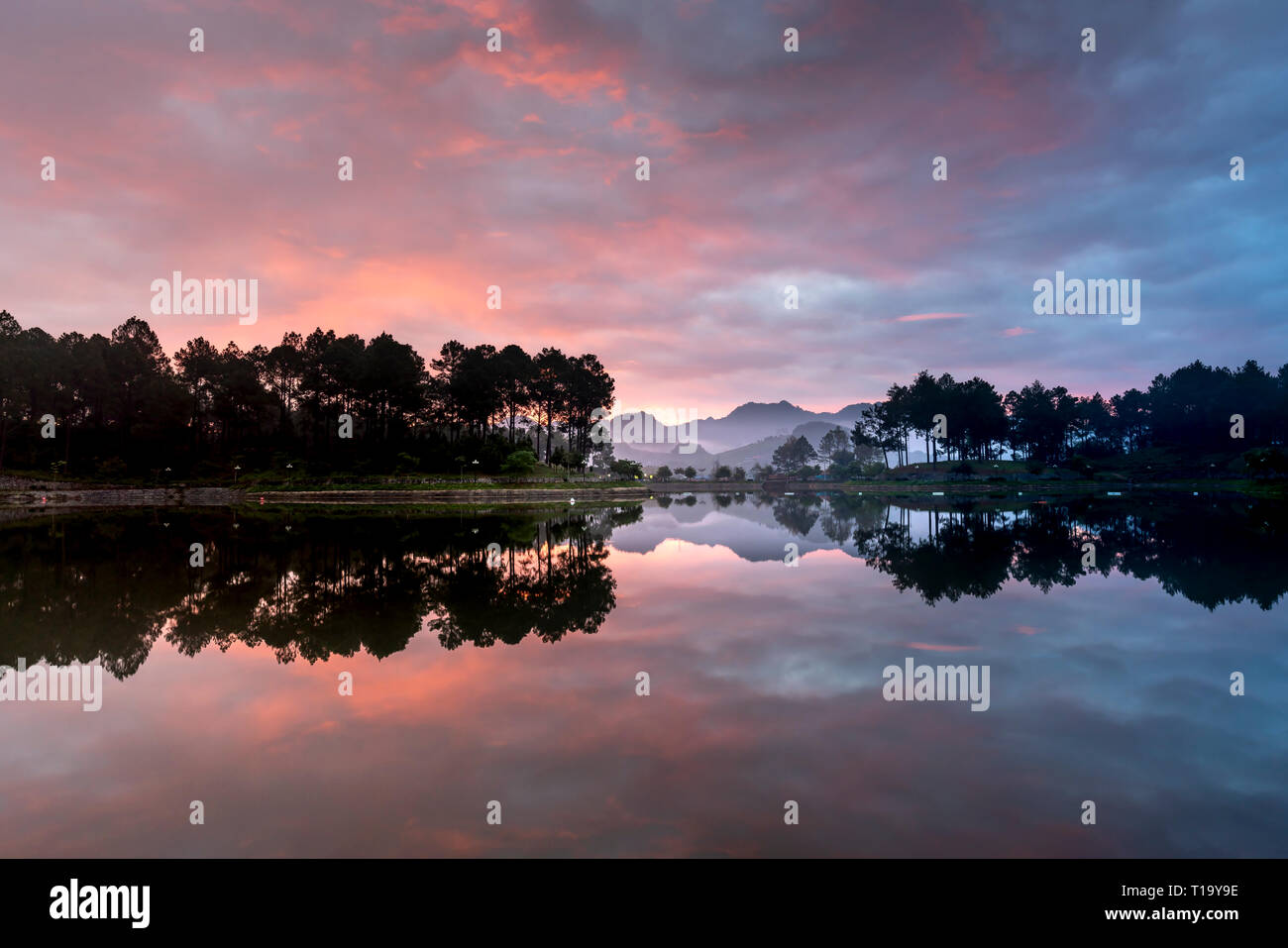 Schöne Dämmerung am See mit rosa Wolken und reflektierenden Sonnenstrahlen bei Ban Ang Dorf, Moc Chau, Son La Provinz, Vietnam Stockfoto