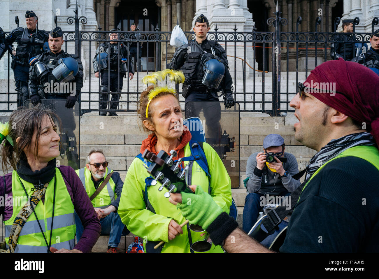 Demonstranten skandierten vor einer Gruppe von Polizisten bewachen den Eingang des Sacre Coeur Basilika. Im XIX Akt der Französischen gelbe Weste Bewegung, die Demonstranten versammeln sich am Fuße der Basilika Sacré Coeur, nördlich von Paris. Stockfoto