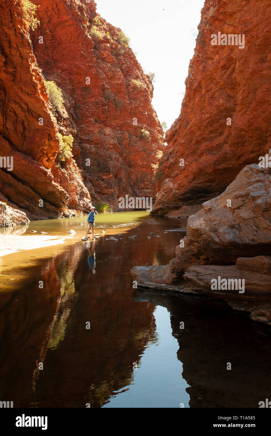 Ein kleiner Junge spielt auf dem Sprungbrett in die Untiefen der Simpsons Gap, Northern Territory, Australien Stockfoto