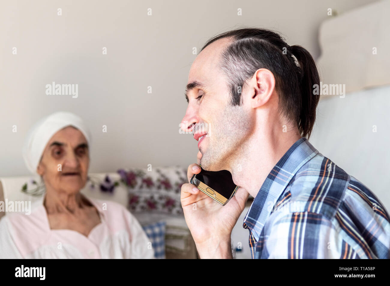 Portrait eines glücklichen, stattlich, kaukasischer Mann mit stoppelbart Gespräch am Handy im Zimmer. Stockfoto