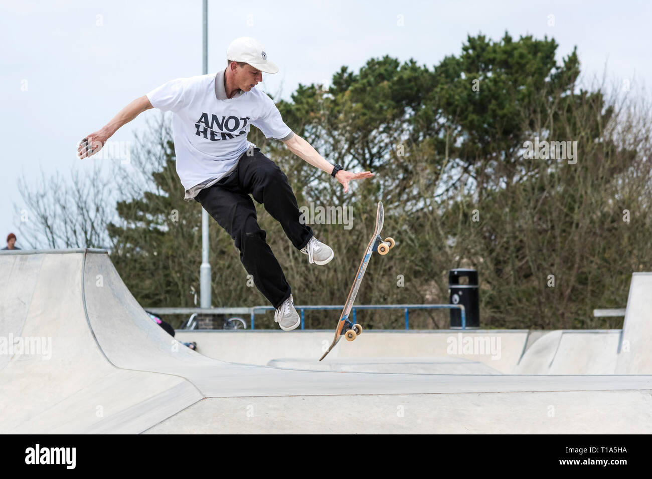Ein Skateboarder versucht, eine Antenne Trick an konkreten Wellen Skateboard Park in Newqay in Cornwall. Stockfoto