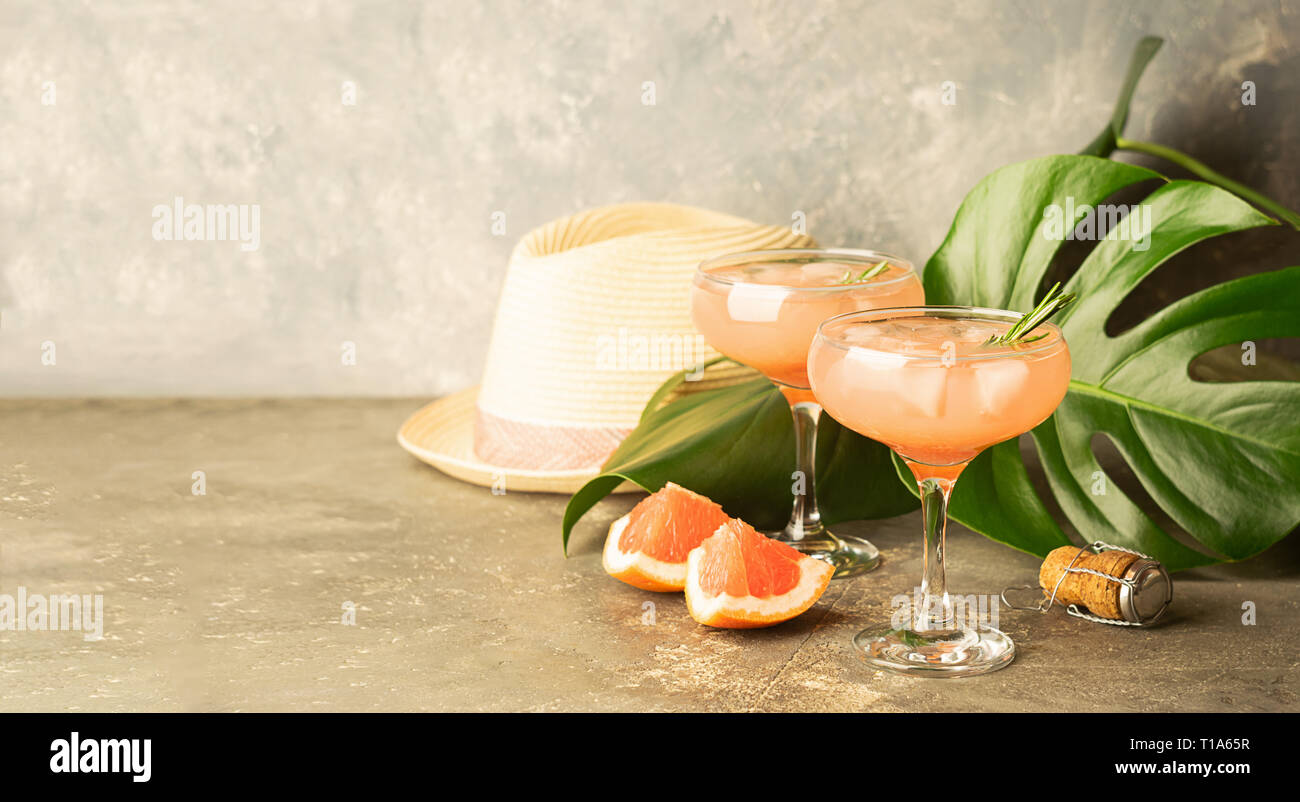 Trinken grapefruit Rosmarin und Eis in zwei eleganten Glas Pokale auf grauem Beton Hintergrund. Selektive konzentrieren. Kopieren Sie Platz. Stockfoto