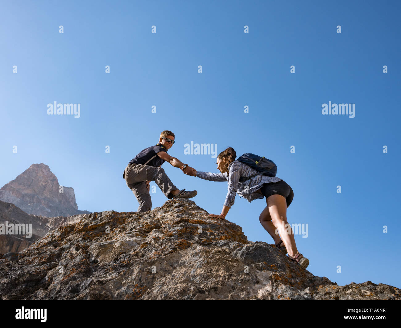 Helfende Hand paar Wanderer in den Bergen Stockfoto