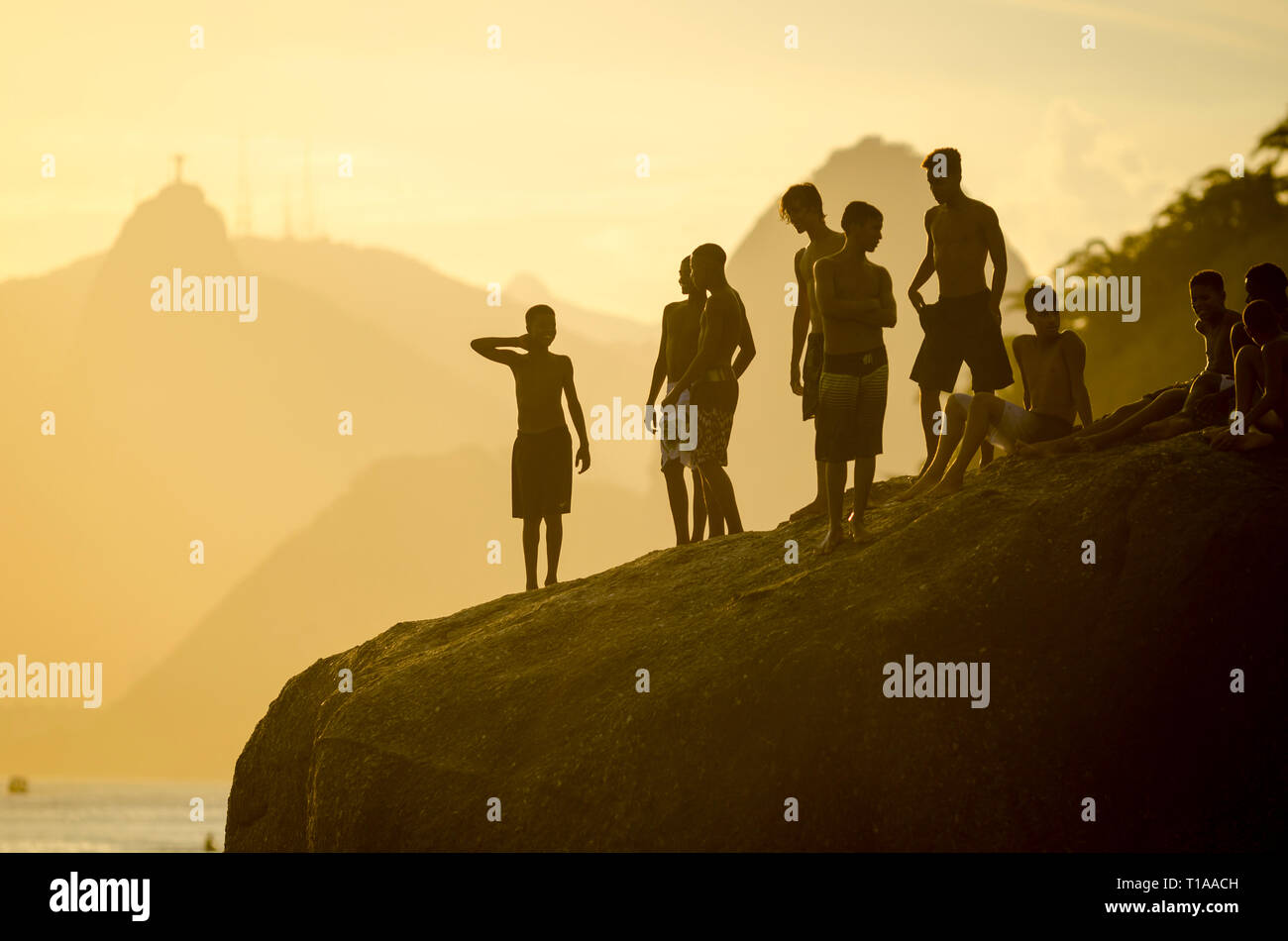 RIO DE JANEIRO - März 4, 2017: Junge Brasilianer versammeln sich auf einem großen Felsen Vorbereitung in das Meer bei Niteroi zu springen, über die Guanabara-bucht von Corcovado Stockfoto
