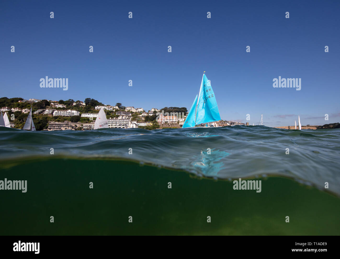 Eine Yacht segeln Vergangenheit während des Salcombe Stadt Regatta unter einem wunderschönen blauen Himmel. Stockfoto