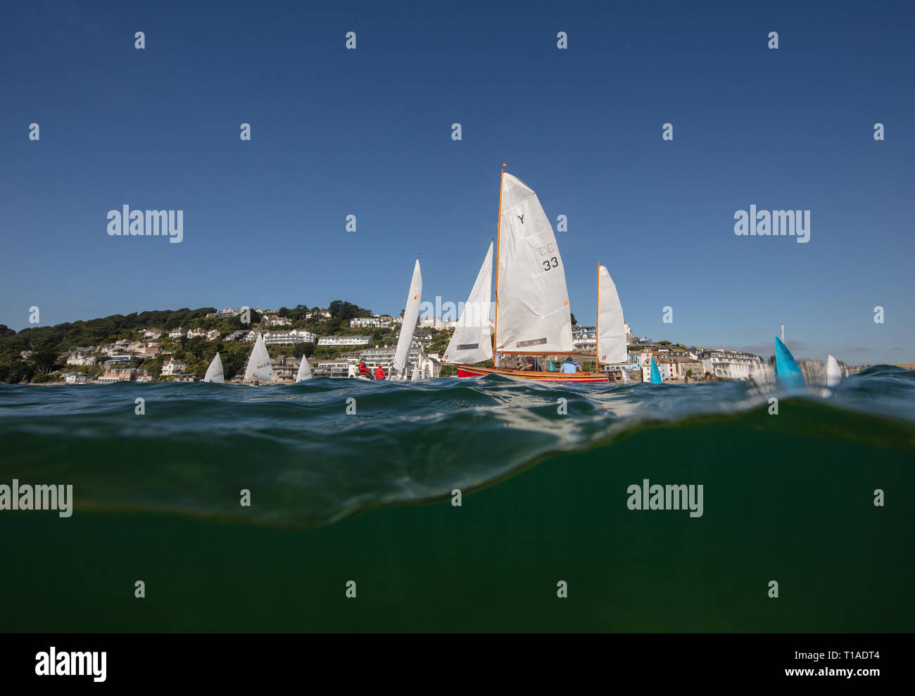 Eine Yacht segeln Vergangenheit während des Salcombe Stadt Regatta unter einem wunderschönen blauen Himmel. Stockfoto