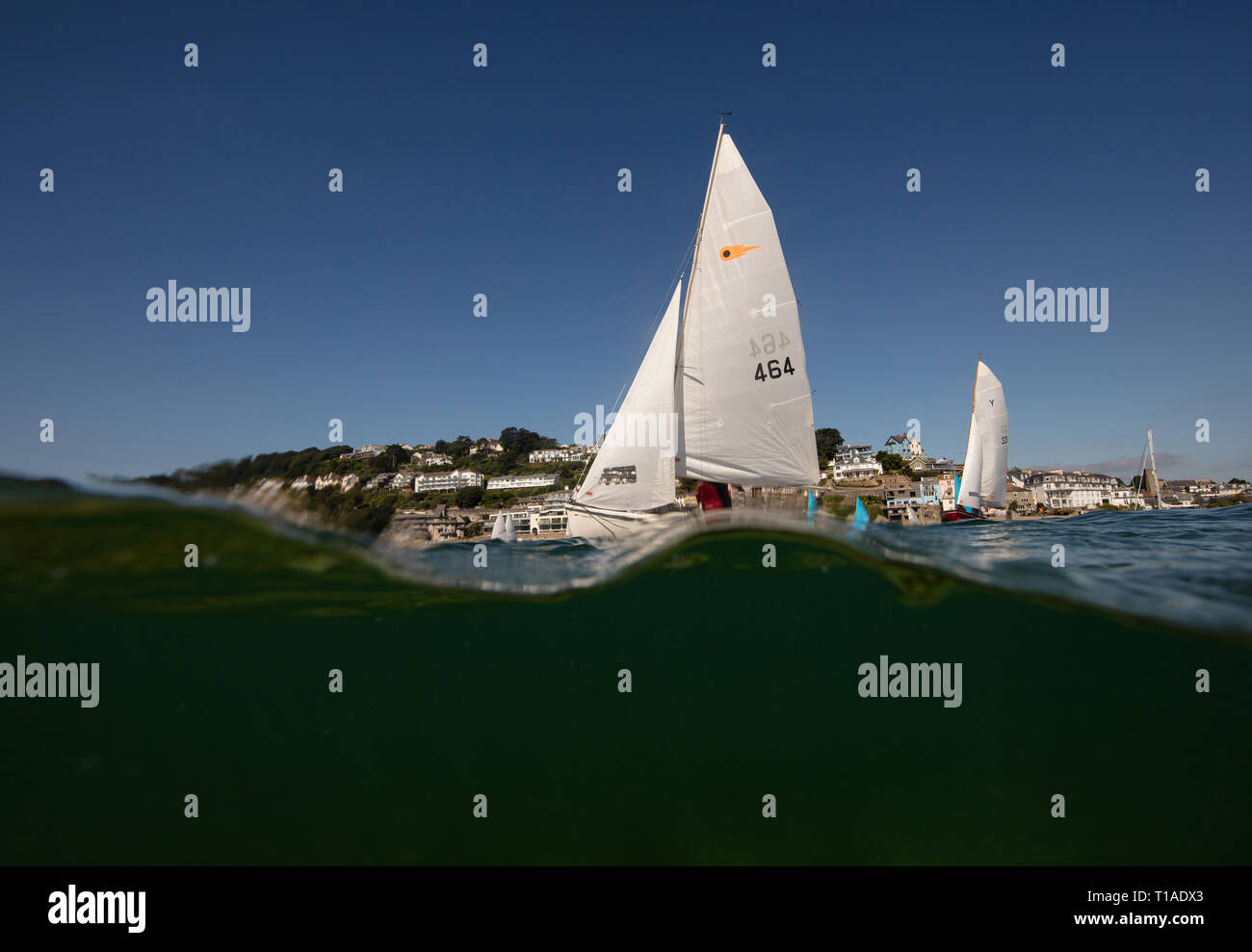 Eine Yacht segeln Vergangenheit während des Salcombe Stadt Regatta unter einem wunderschönen blauen Himmel. Stockfoto