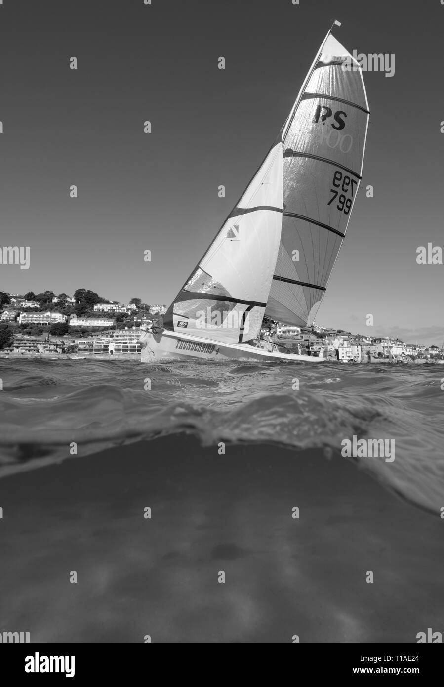 Eine Yacht segeln Vergangenheit während des Salcombe Stadt Regatta unter einem wunderschönen blauen Himmel. Stockfoto