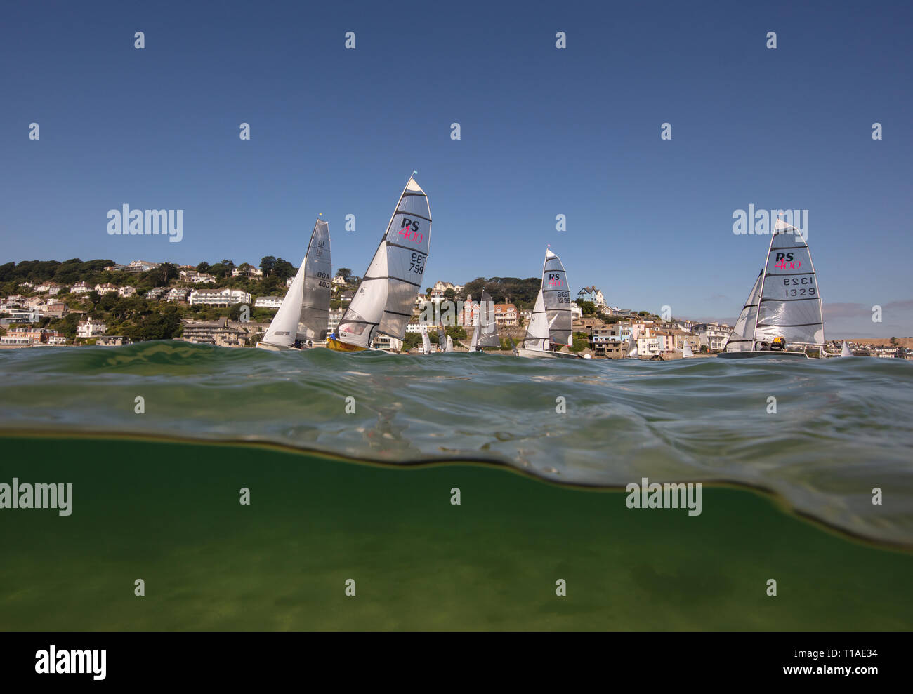 Eine Yacht segeln Vergangenheit während des Salcombe Stadt Regatta unter einem wunderschönen blauen Himmel. Stockfoto
