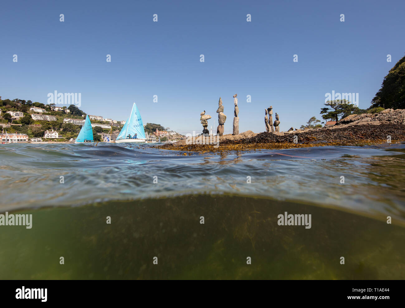 Eine Yacht segeln Vergangenheit während des Salcombe Stadt Regatta unter einem wunderschönen blauen Himmel. Stockfoto