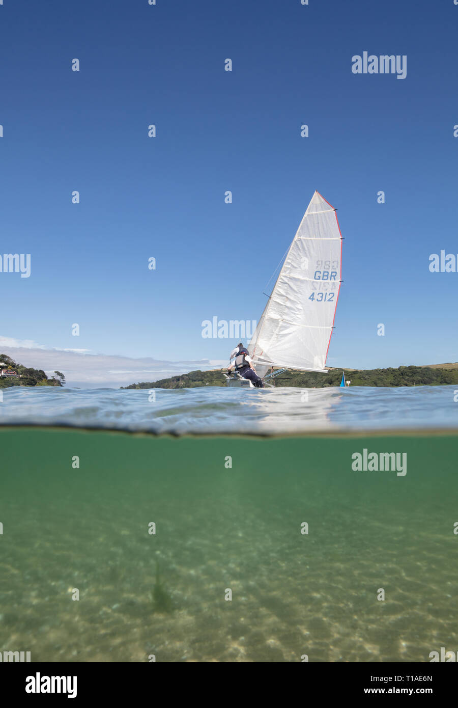 Eine Yacht segeln Vergangenheit während des Salcombe Stadt Regatta unter einem wunderschönen blauen Himmel. Stockfoto