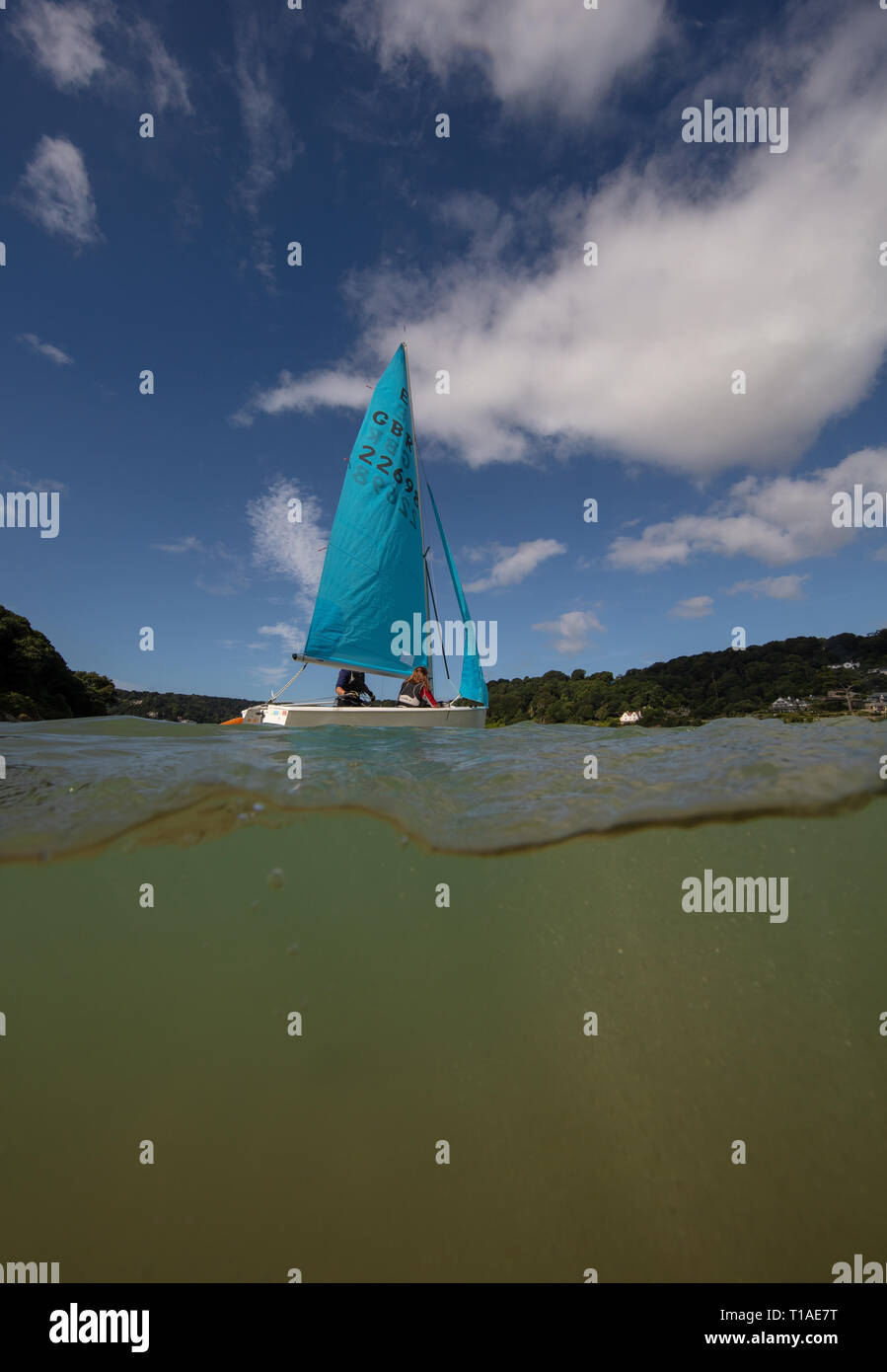Eine Yacht segeln Vergangenheit während des Salcombe Stadt Regatta unter einem wunderschönen blauen Himmel. Stockfoto