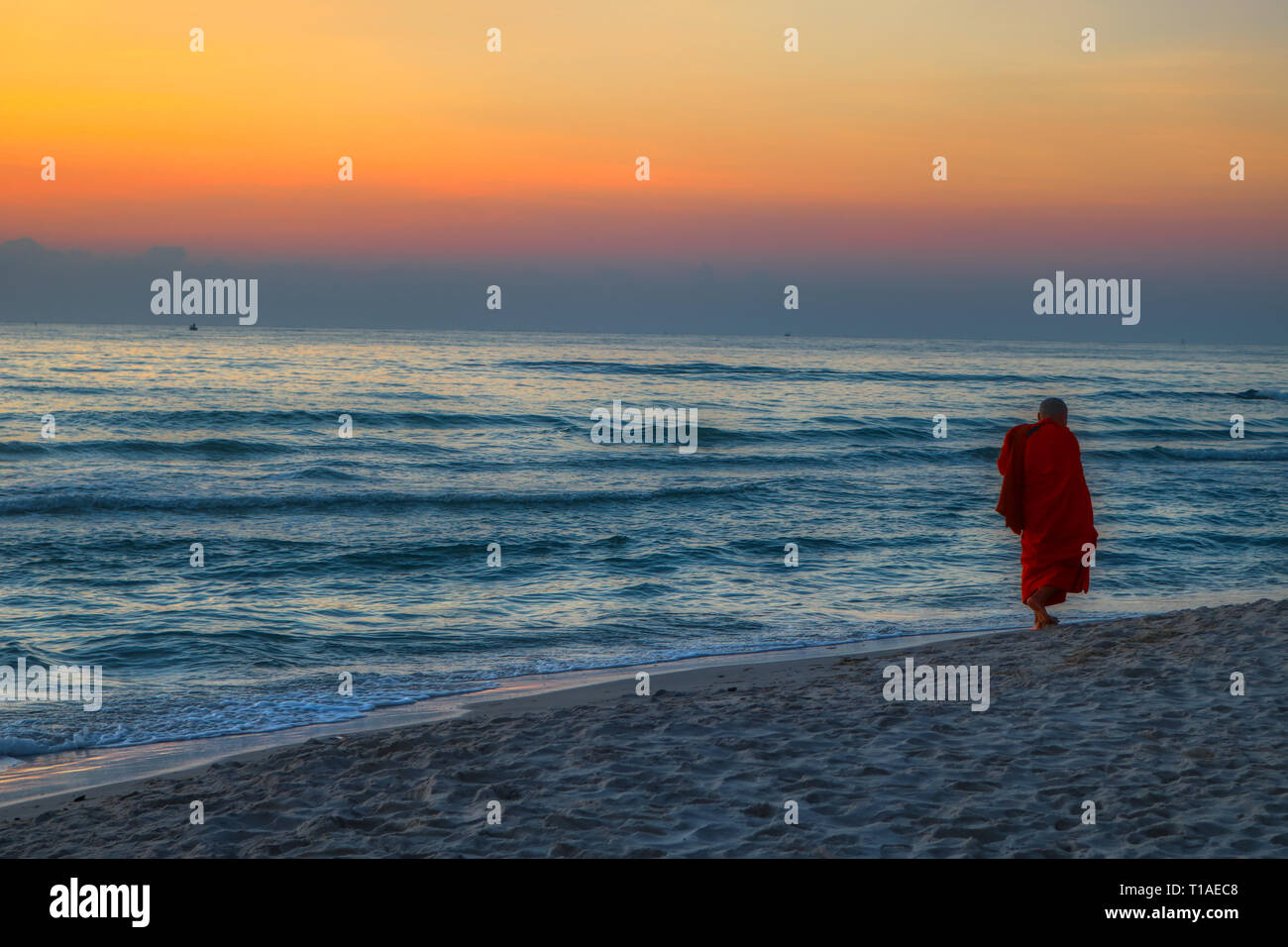 Das große Foto zeigt den Sonnenaufgang von Hua Hin in Thailand am frühen Morgen bei Sonnenaufgang. Am Strand können Sie ein buddhistischer Mönch zu Fuß Stockfoto