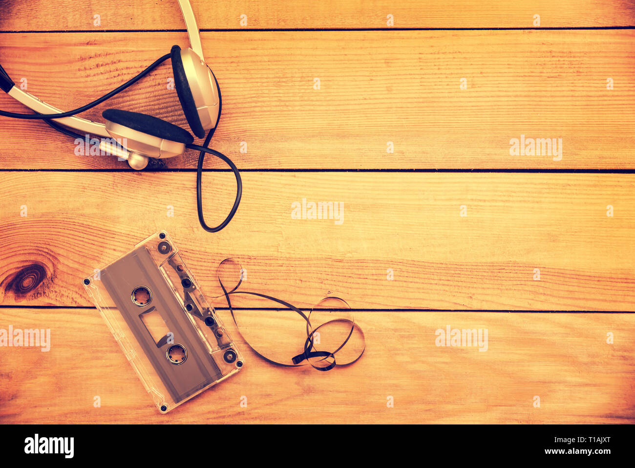 Kopfhörer und transluzente Audio Cassette auf vintage Holzplanken Hintergrund weiß Kopie Raum Stockfoto