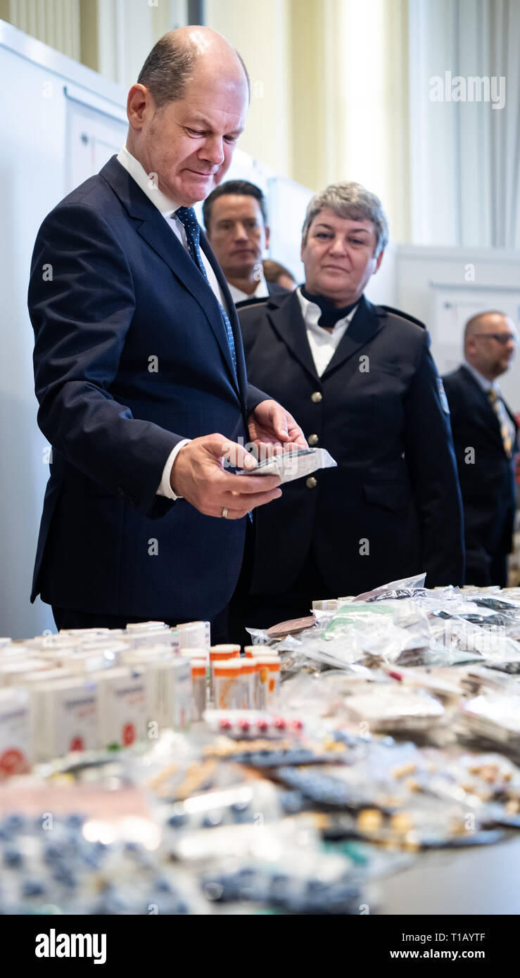 Berlin, Deutschland. 25 Mär, 2019. Olaf Scholz (l, SPD), Bundesfinanzminister und Colette Hercher, Präsident von der Oberzolldirektion, werfen Sie einen Blick auf Beschlagnahmten waren bei der Pressekonferenz auf dem Zoll Balance 2018 im Bundesministerium der Finanzen. Foto: Bernd von Jutrczenka/dpa Quelle: Bernd von Jutrczenka/dpa/Alamy leben Nachrichten Stockfoto