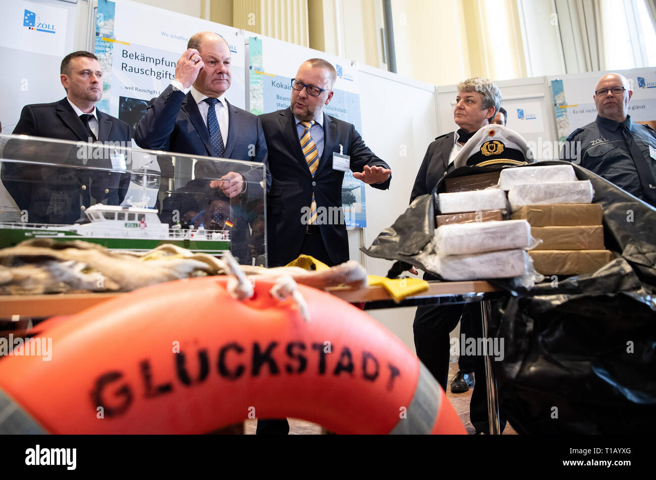 Berlin, Deutschland. 25 Mär, 2019. Olaf Scholz (2. von links, SPD), Bundesfinanzminister und Colette Hercher (2. von rechts), Präsident der Generaldirektion, Blick an beschlagnahmten Waren bei der Pressekonferenz auf dem Zoll Balance 2018 im Bundesministerium der Finanzen. Foto: Bernd von Jutrczenka/dpa Quelle: Bernd von Jutrczenka/dpa/Alamy leben Nachrichten Stockfoto