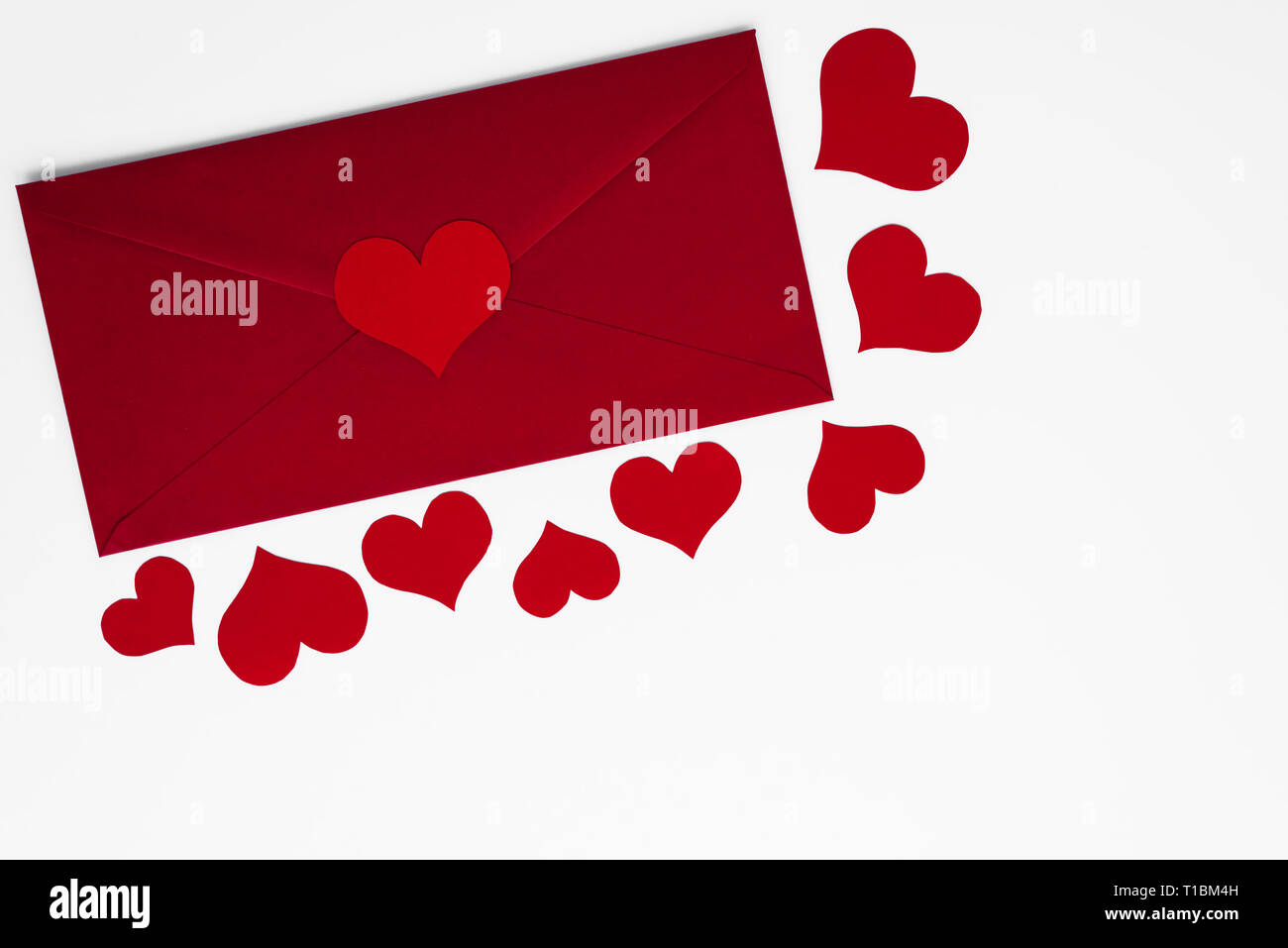Konzept der Liebe im roten Umschlag von romantischen roten Herzen auf weißem Hintergrund umgeben. Kopieren Sie Raum für Happy Valentines Grüße. Mütter oder nicht Stockfoto