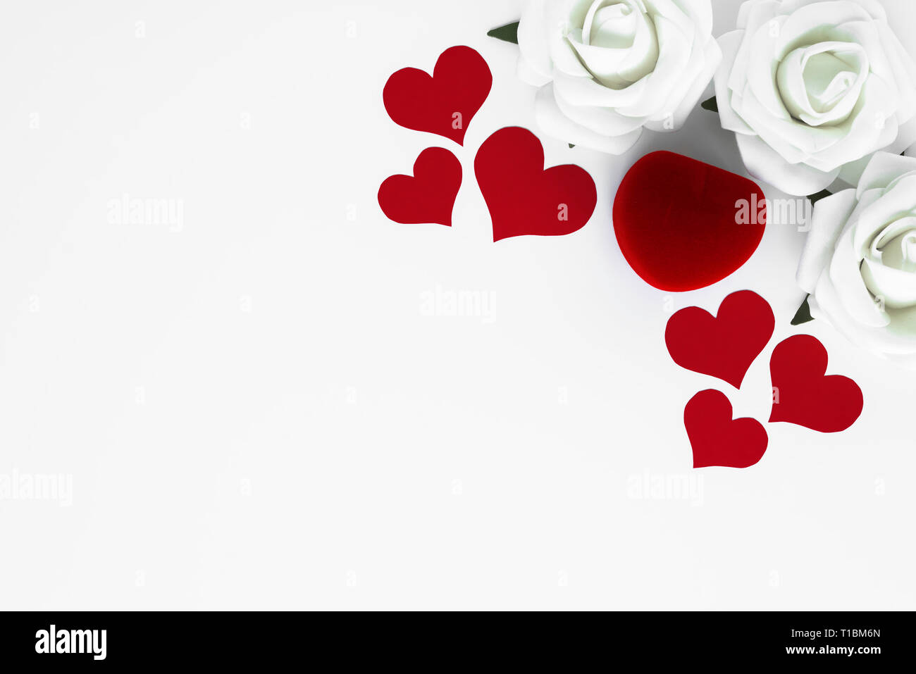 Einrichten von roten Herzen, weiße Rosen und dekorativen Box für Verlobungsring, alle auf weißem Hintergrund mit Kopie Platz für Text über die Liebe. Apropos Stockfoto