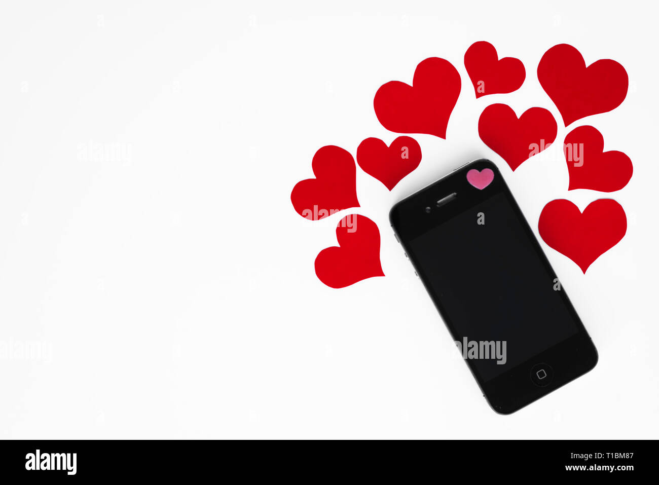 Mockup am Telefon mit romantischen rote Herzen um ihn herum, alle auf weißem Hintergrund mit Kopie Raum für Happy Valentines Text. Konzept der smartphone Nachricht w Stockfoto