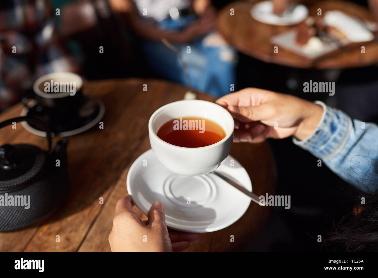Frau sitzt in einem Café Tabelle Tee trinken. Stockfoto