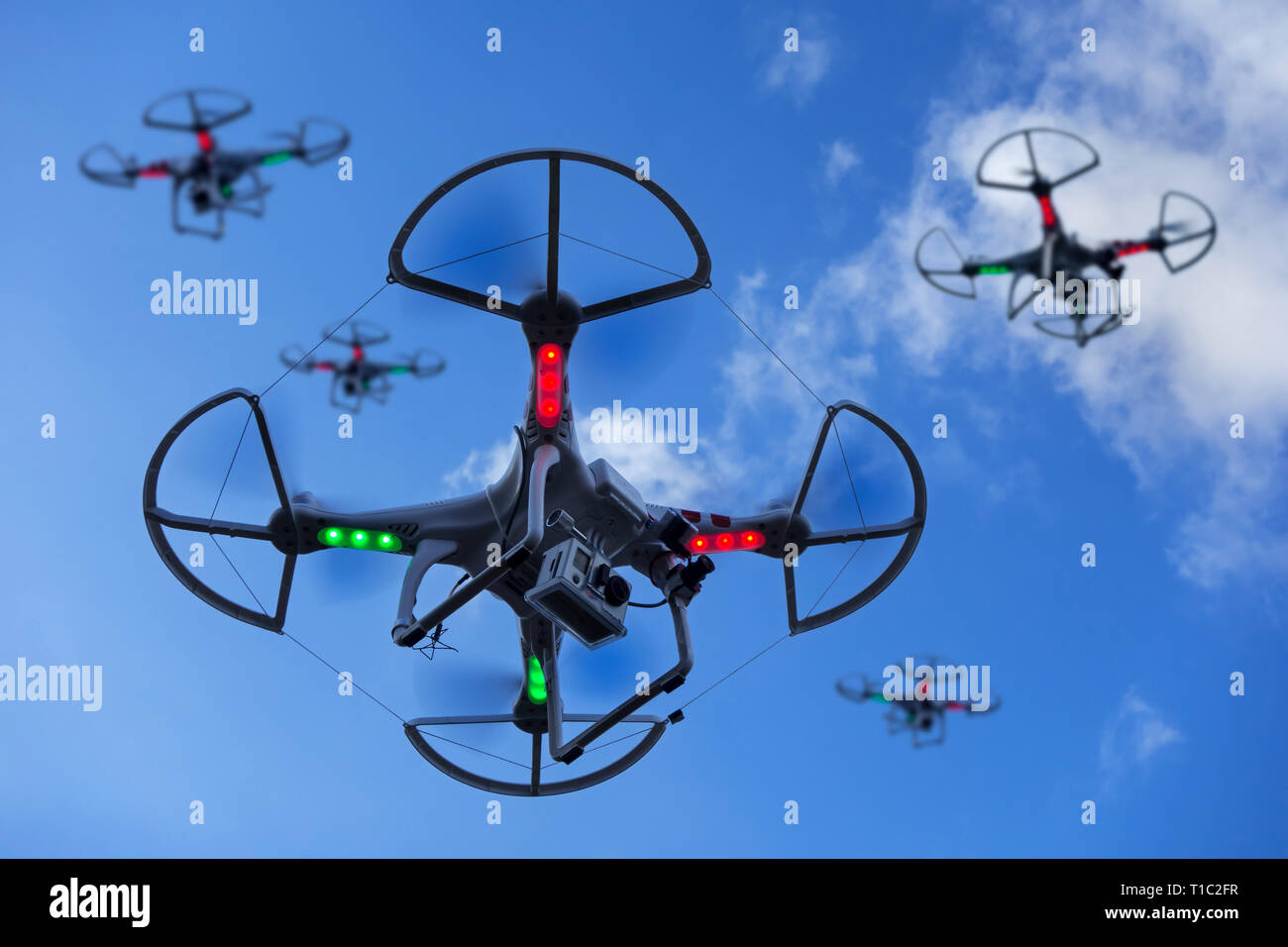 Gruppe von Miniatur Drohnen/unbemannte Fahrzeuge/UAV mit Kamera im Flug gegen den blauen Himmel mit Wolken ausgestattet Stockfoto