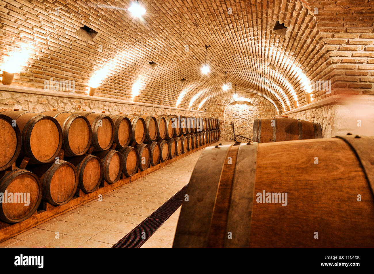 Restaurant storage Holzfässer mit Wein. Weingut Keller mit Ziegel und Steinmauern. Stockfoto