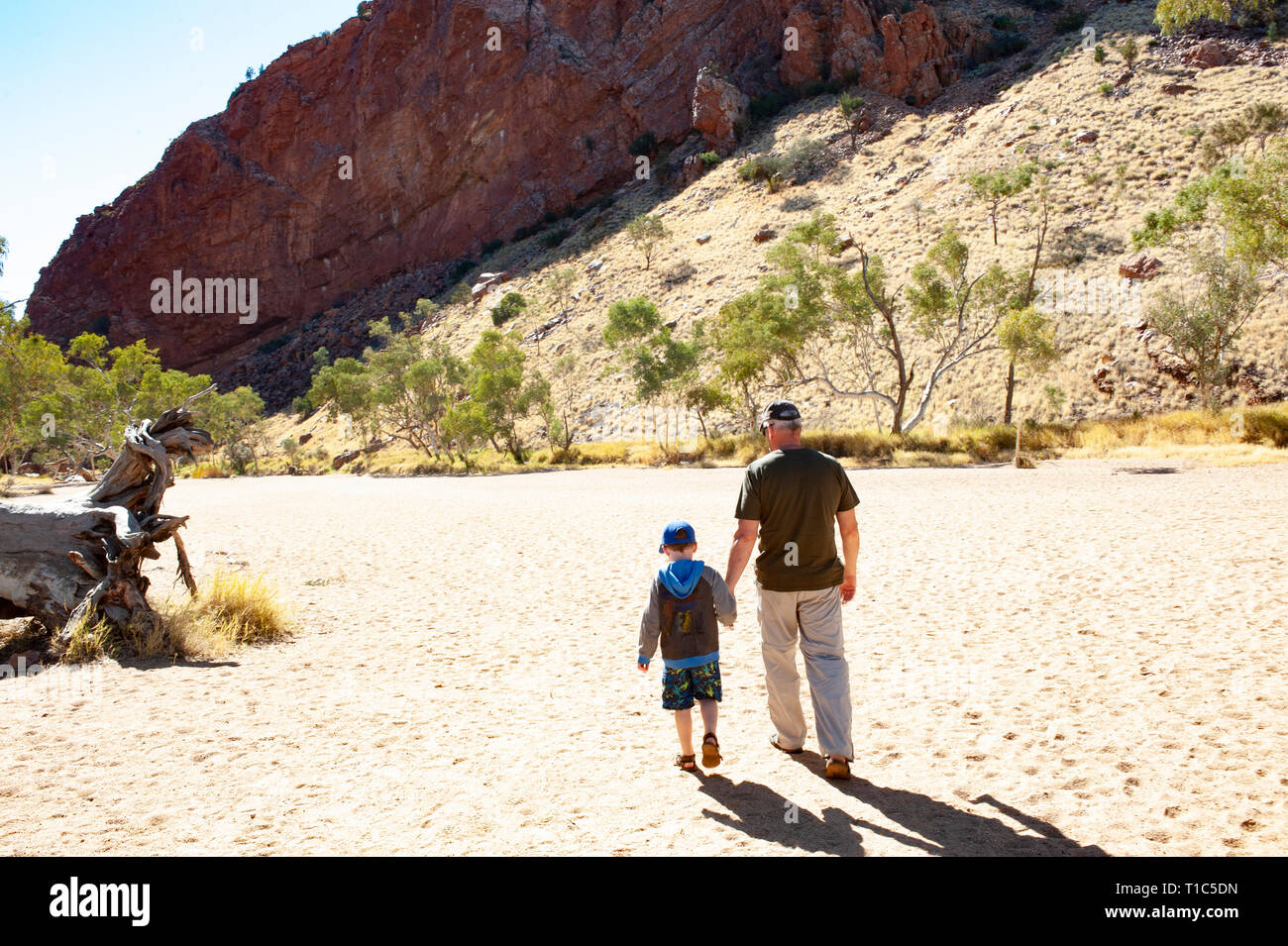 Vater und Sohn halten sich an den Händen zu Fuß durch Simpsons Gap, Northern Territory, Australien Stockfoto