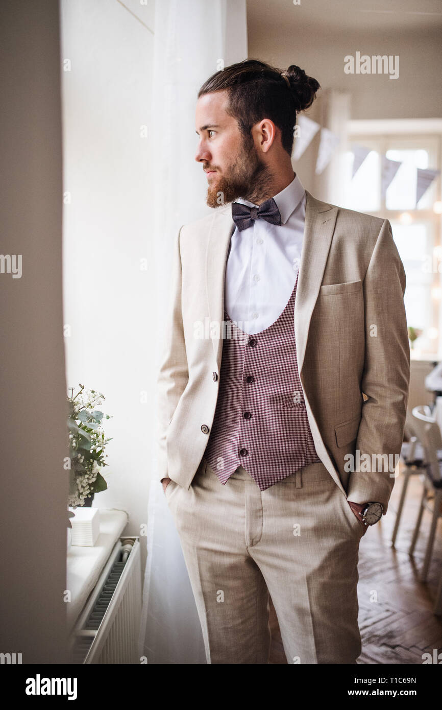 Ein schöner Hipster junger Mann mit Anzug auf der Indoor Party. Stockfoto