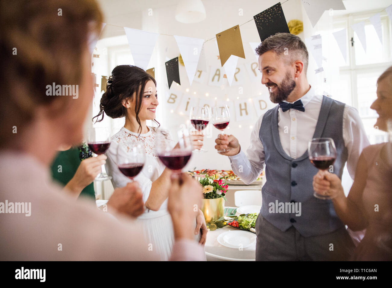 Eine multigeneration Familie Anstoßen auf ein Hallenbad Geburtstagsfeier in der Familie. Stockfoto